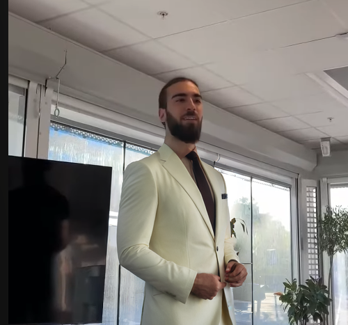 Lennard N. i kostym står framför en skärm i ett kontorsutrymme, representerar Sweden Digital Agency som utvecklare.